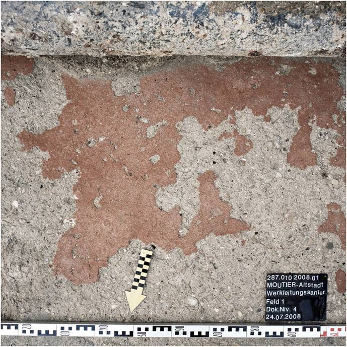 Enduit rouge recouvrant le sol de mortier